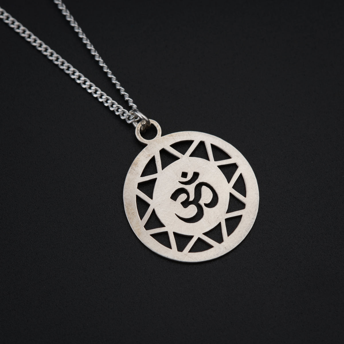 a silver necklace with a symbol on it