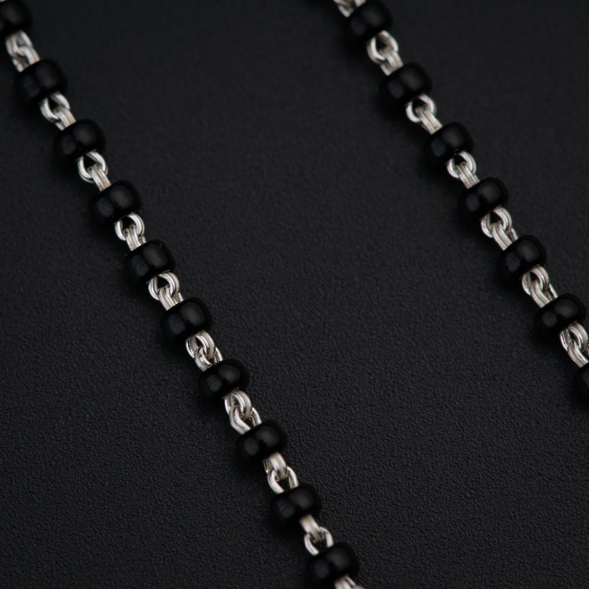 a close up of a black and silver necklace