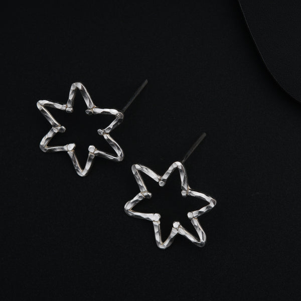 a pair of star shaped earrings on a black surface