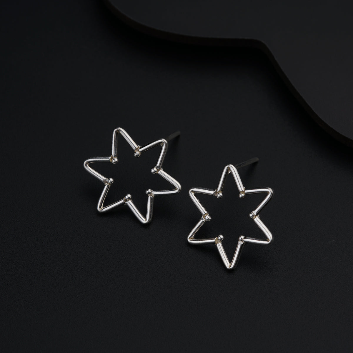 a pair of star shaped earrings sitting on top of a table