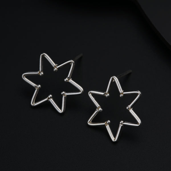 a pair of star shaped earrings sitting on top of a table