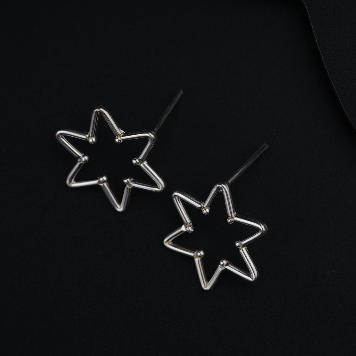 a pair of star shaped earrings on a black surface