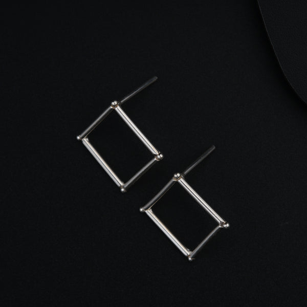 a pair of earrings sitting on top of a black surface