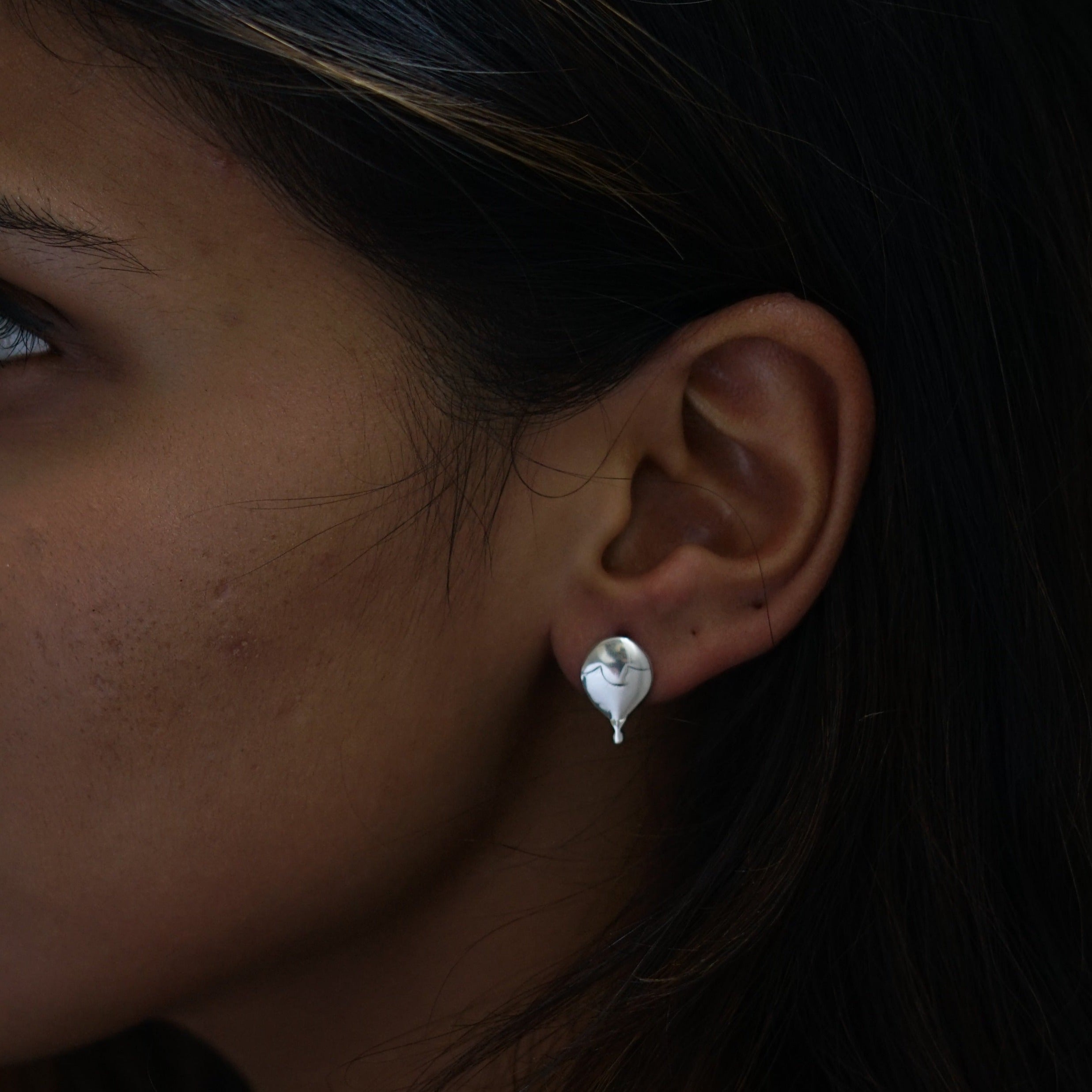 a close up of a person wearing a earring