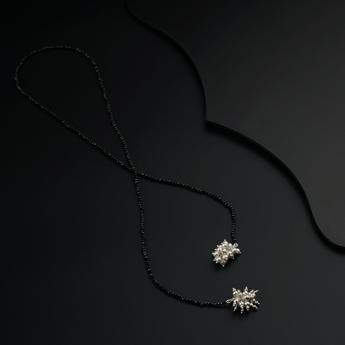 a black necklace with a snowflake pendant