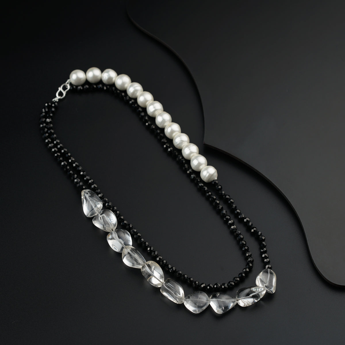 a black and white necklace with pearls and beads