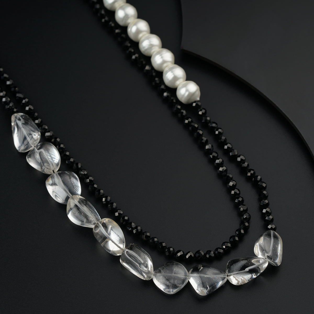 a black beaded necklace with white pearls and black beads