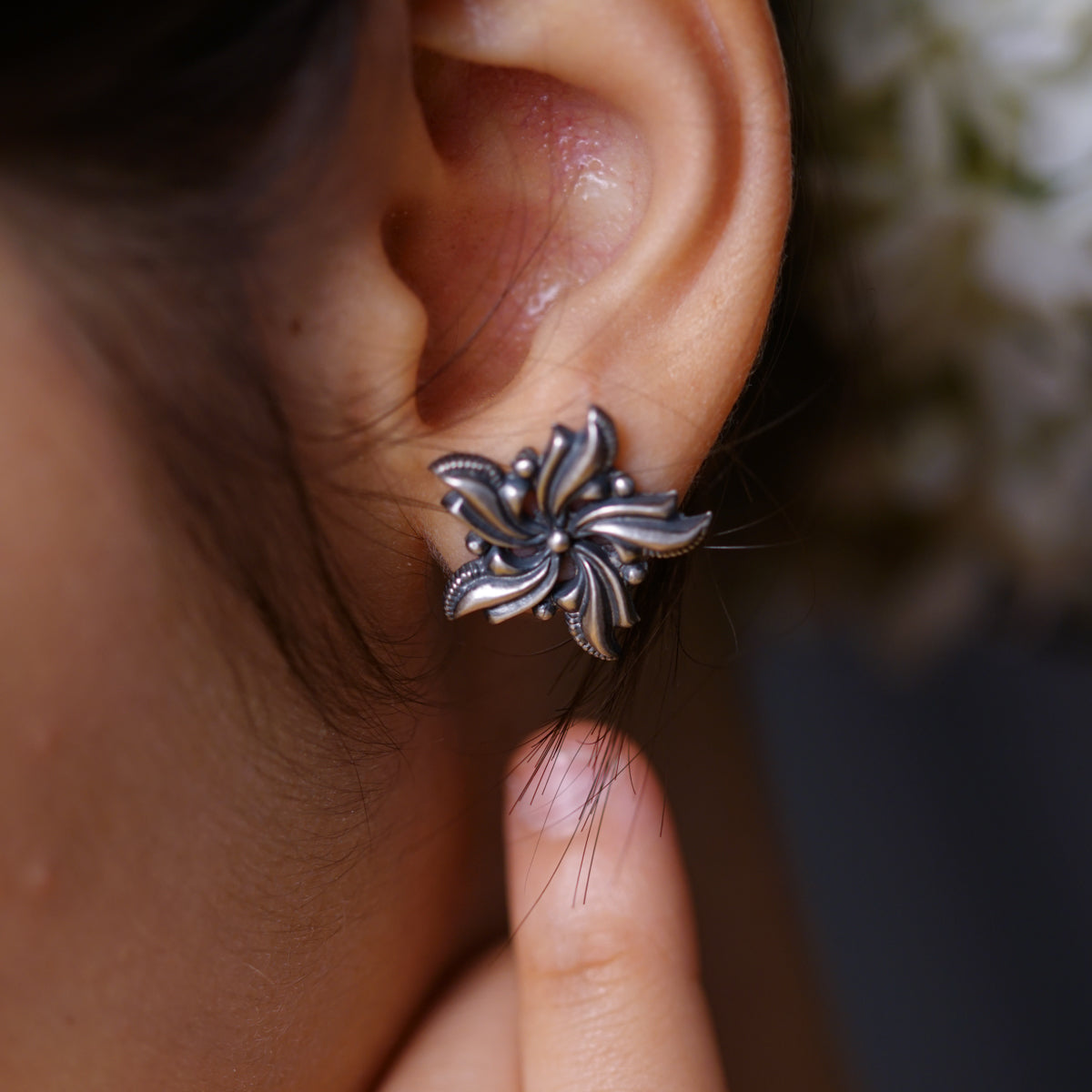 a close up of a person's ear with a flower on it