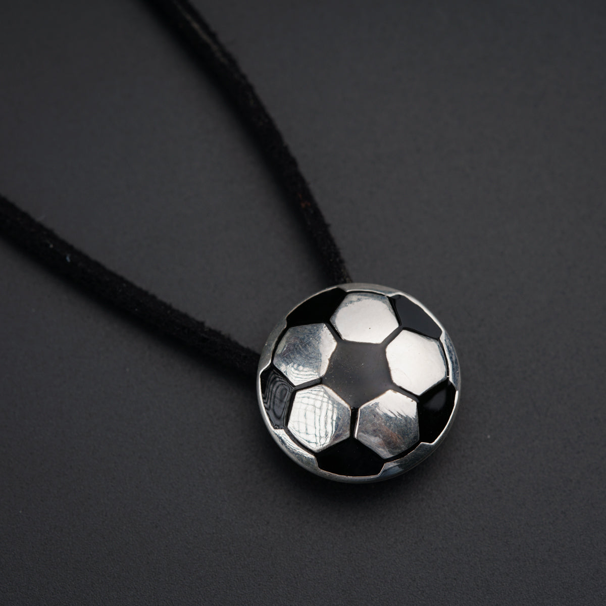 a soccer ball pendant on a black cord