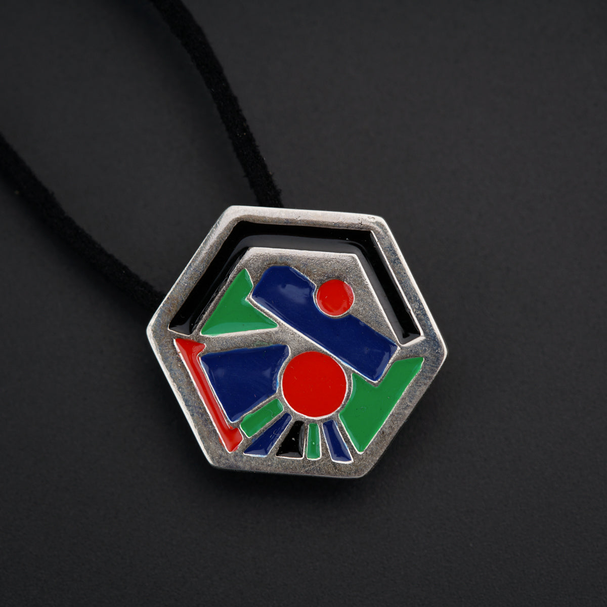 a pendant with a colorful design on a black background