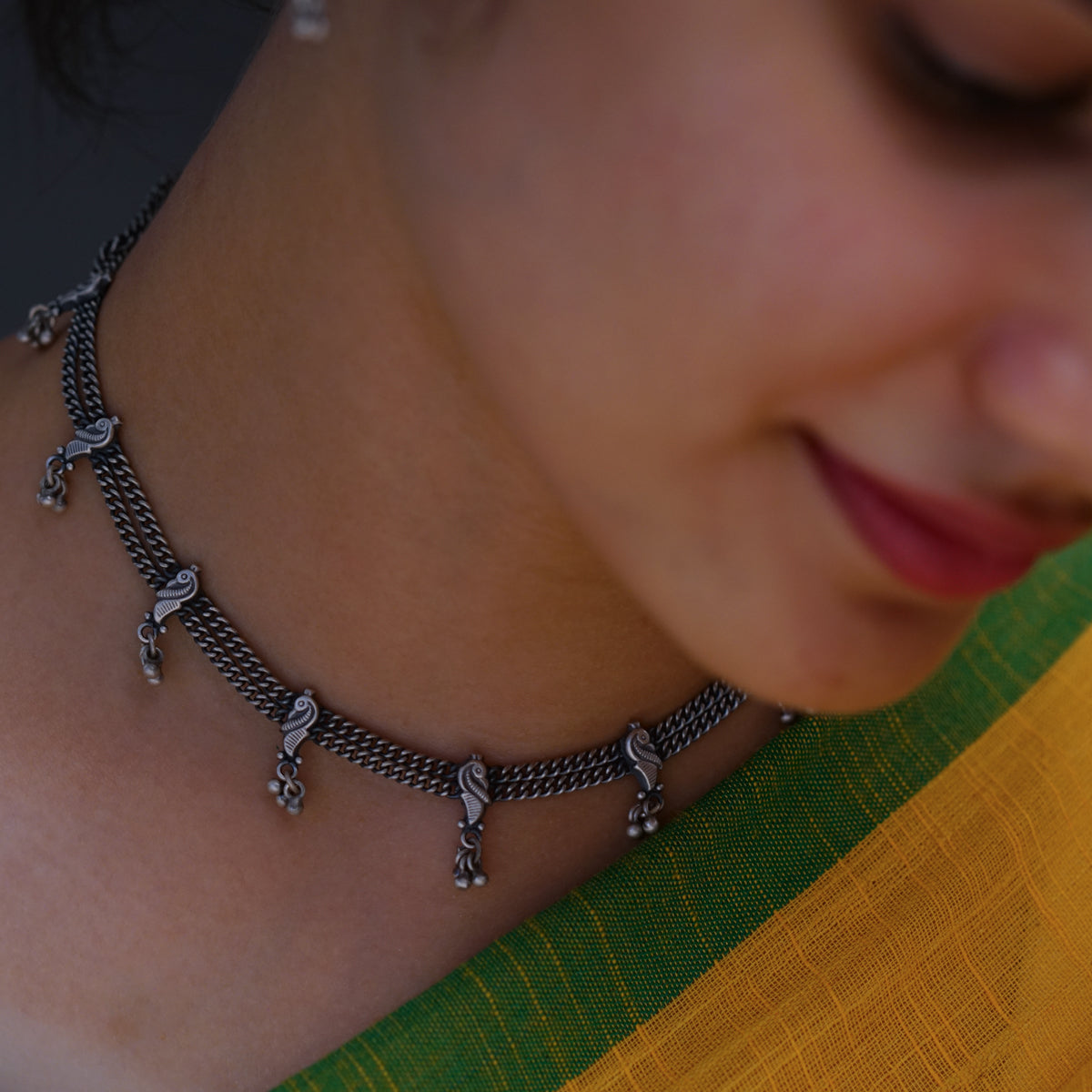 a close up of a woman wearing a necklace