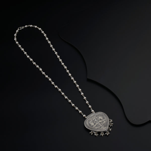 a necklace with a heart shaped pendant on a chain