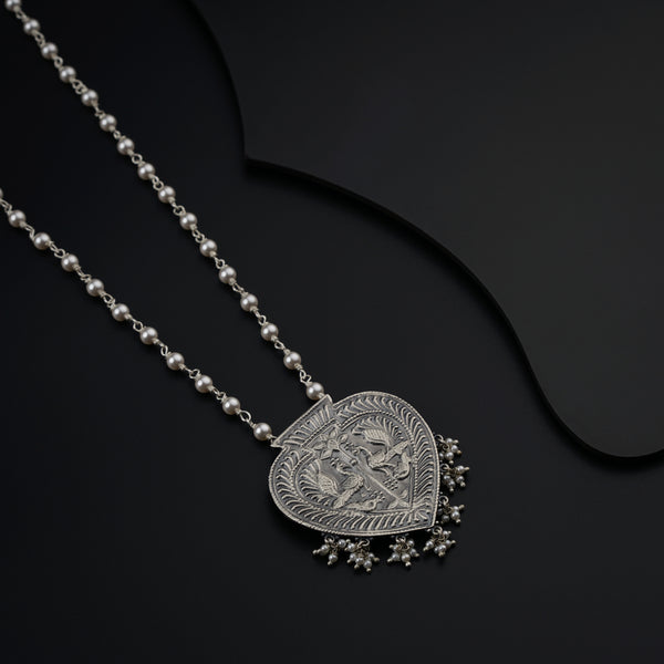 a necklace with a heart shaped pendant on a black background