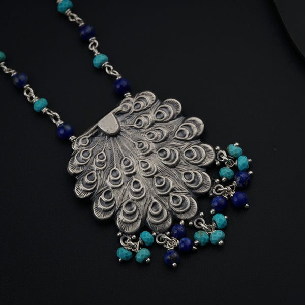 a necklace with a peacock design and blue beads