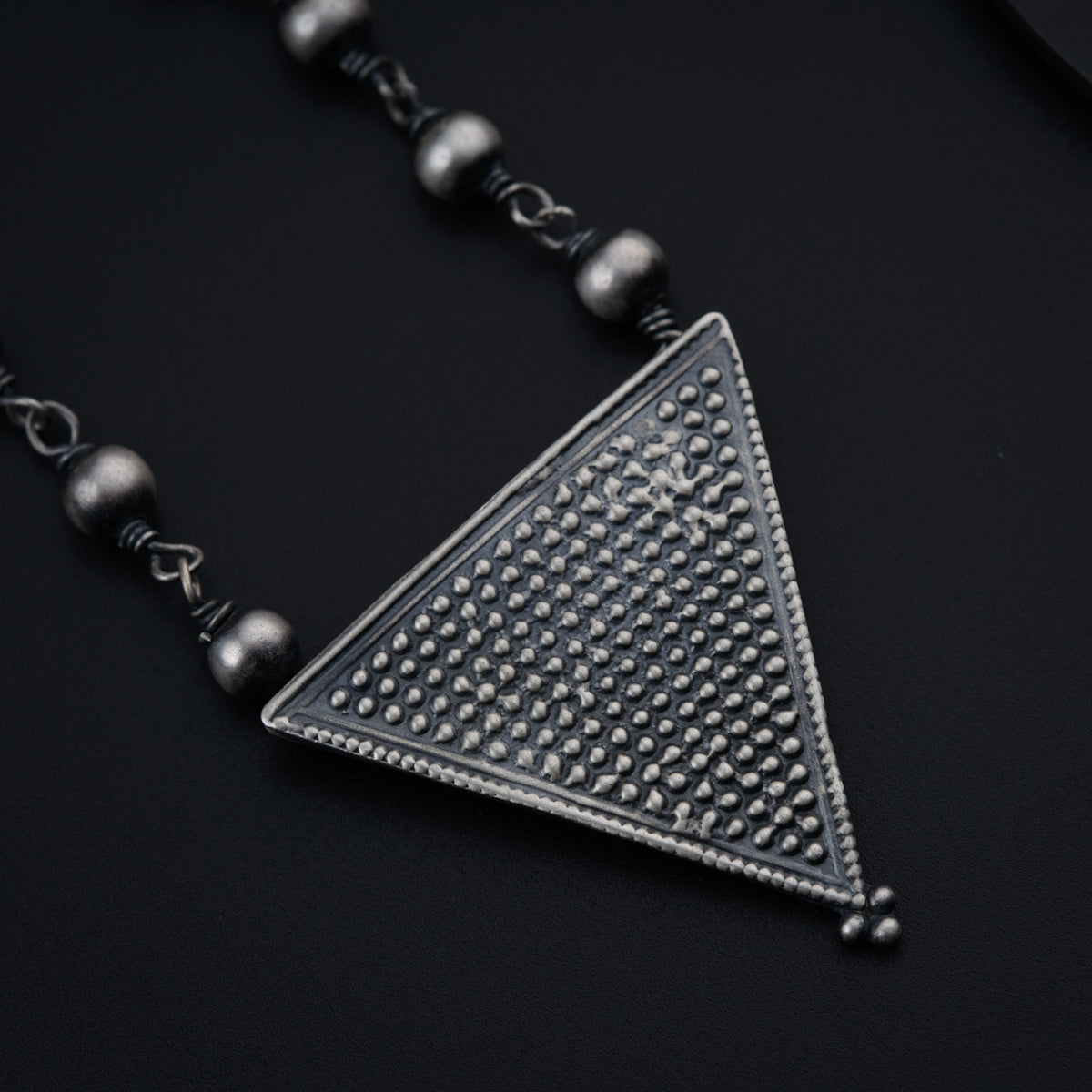 a necklace with a triangle design on it