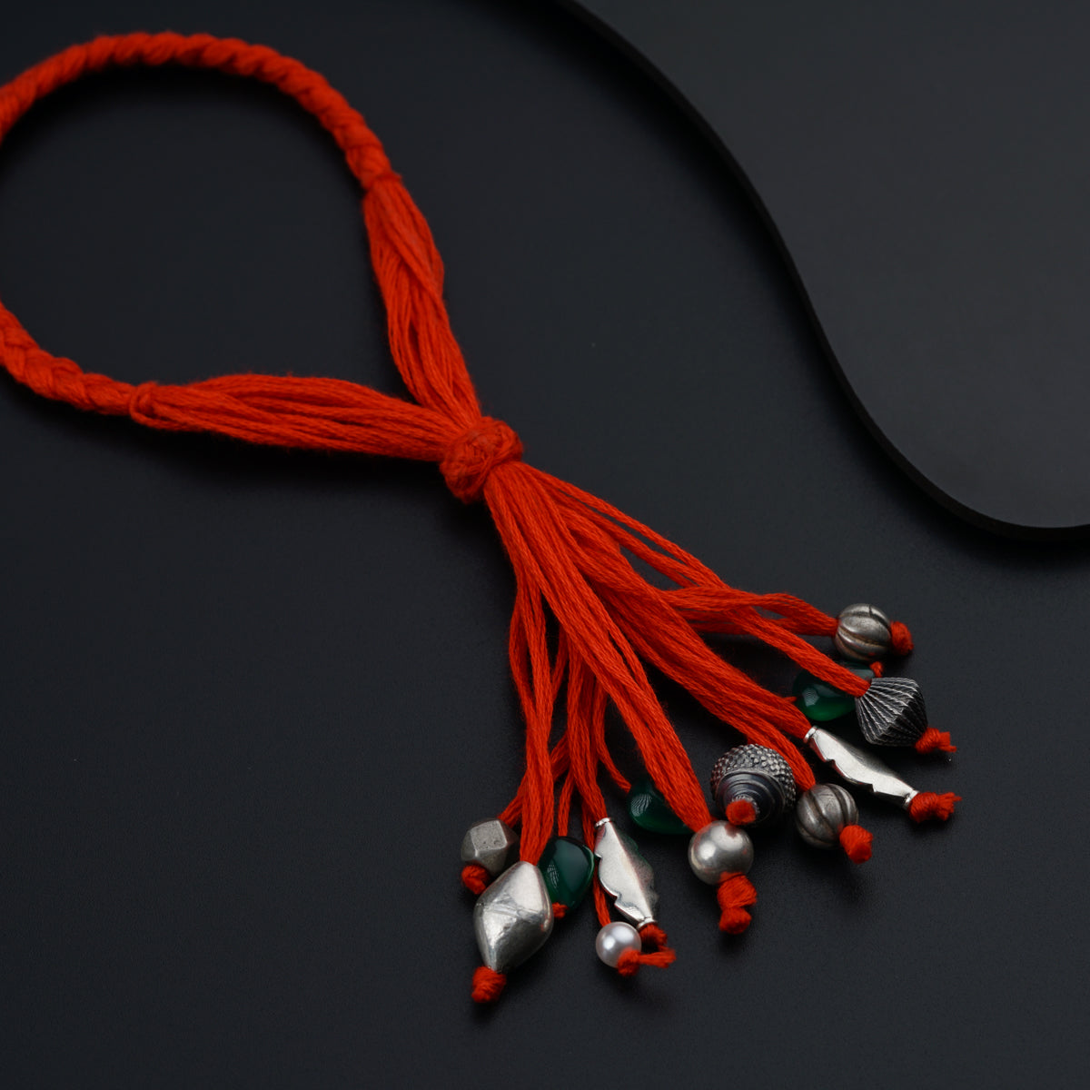 a red string with bells on a black surface