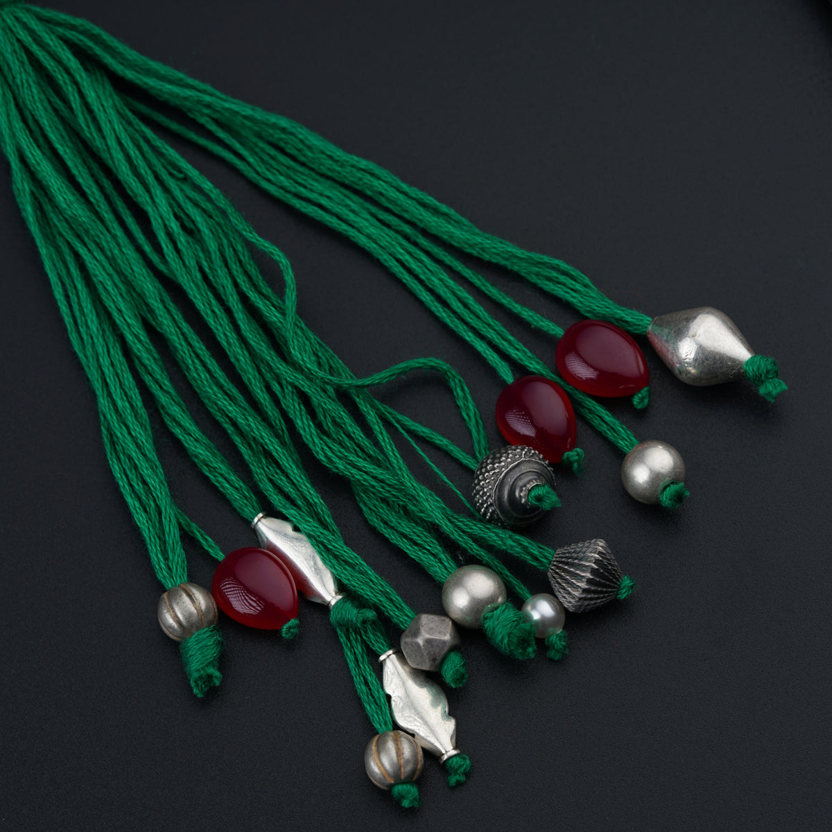 a bunch of beads and tassels on a black surface