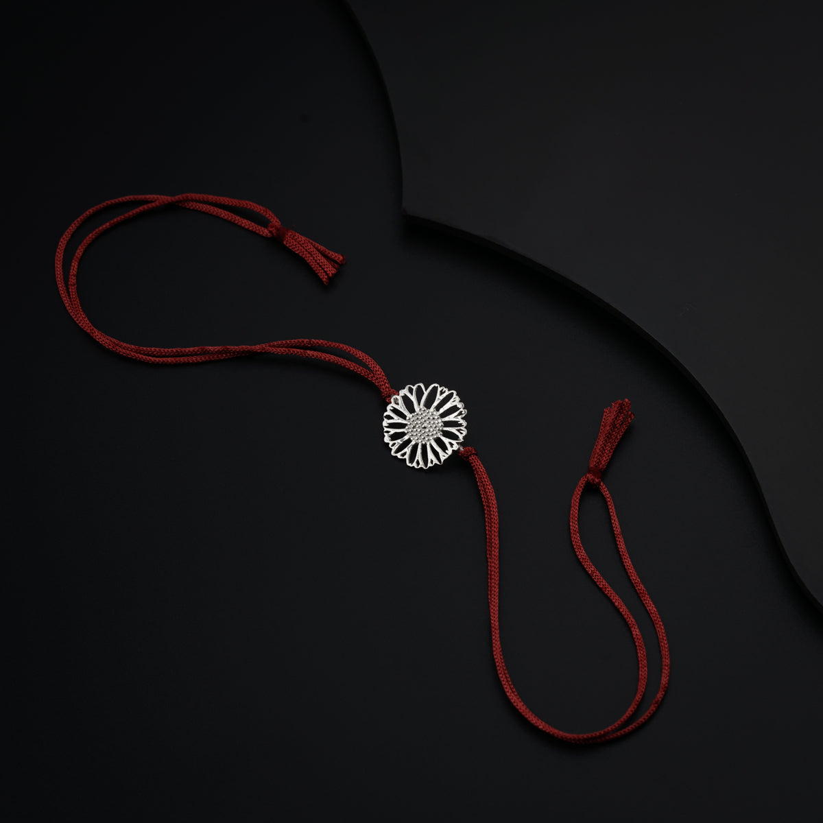 a red string with a brooch hanging from it