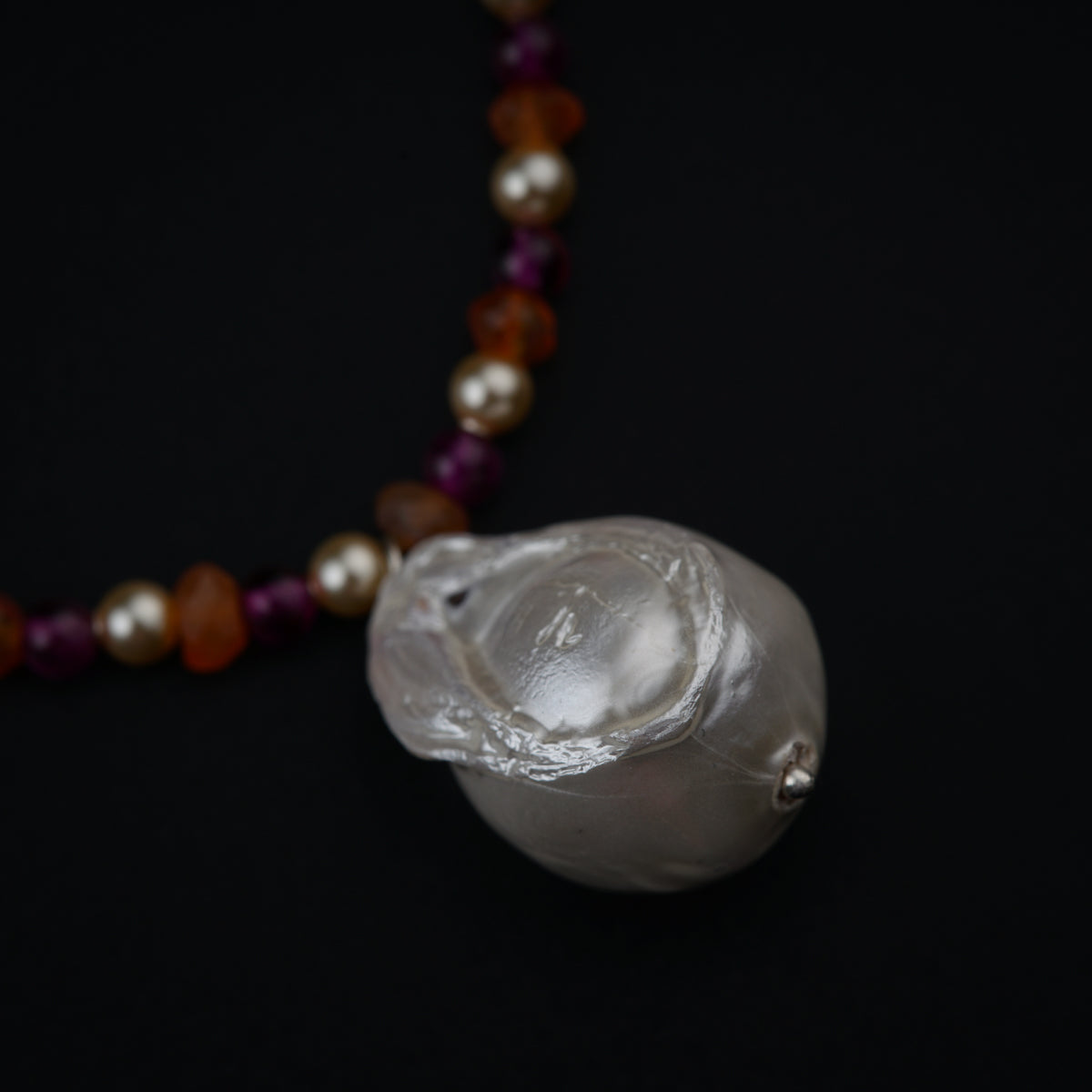 a necklace with a white shell and beads