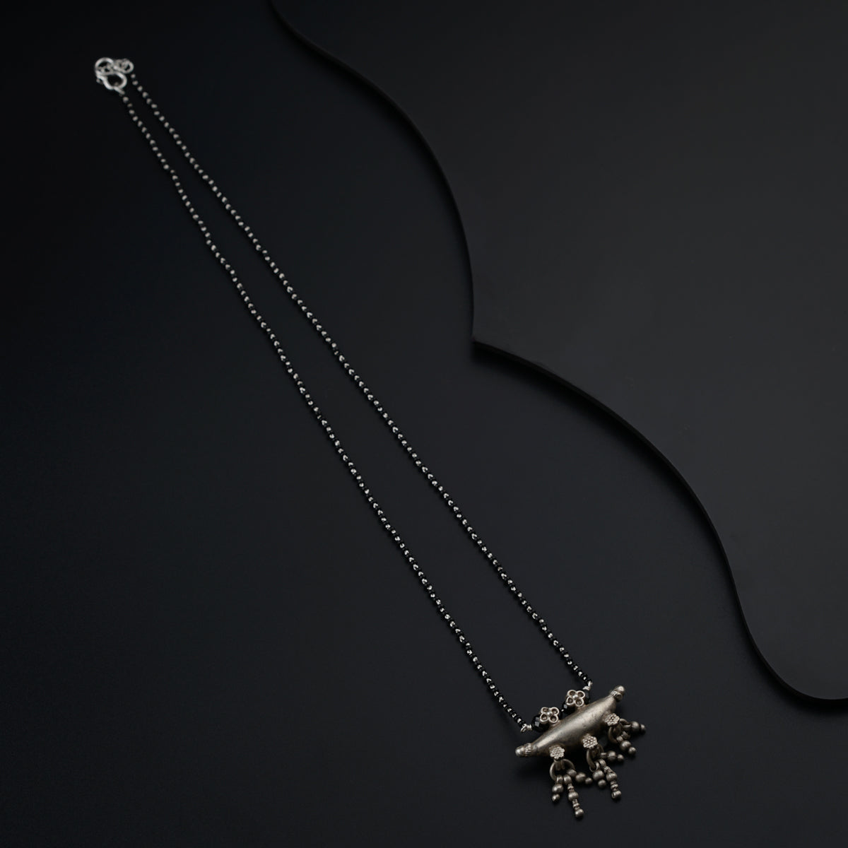 a silver necklace with a silver flower on it