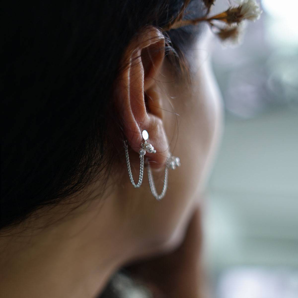 a close up of a person wearing a pair of ear cuffs