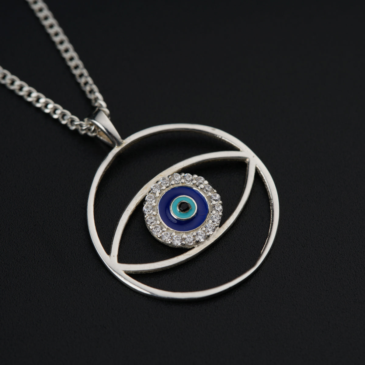 a silver necklace with a blue evil eye on it