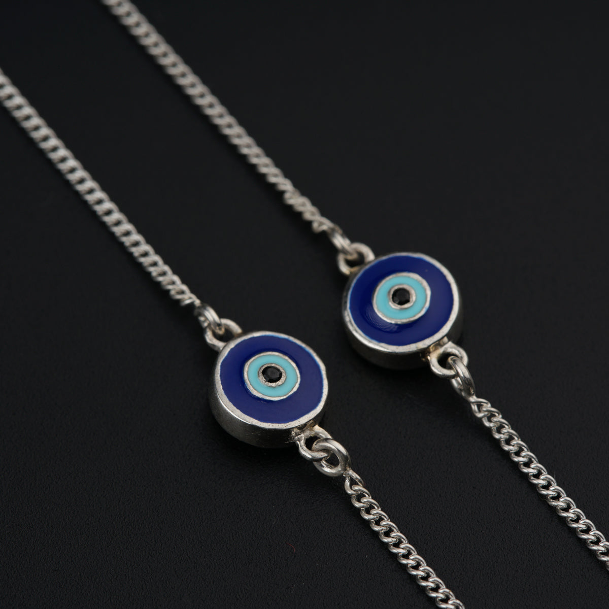 a pair of blue evil eye earrings on a chain
