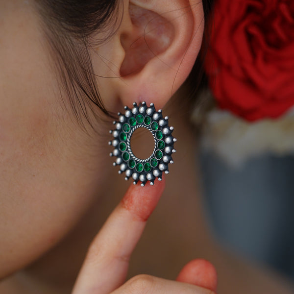 a close up of a person wearing a pair of earrings