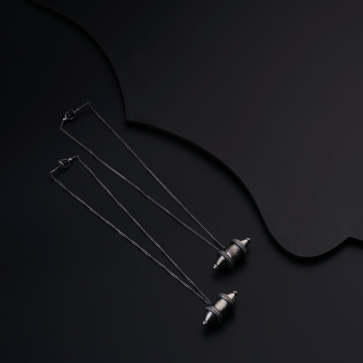 a group of three necklaces sitting on top of a black surface