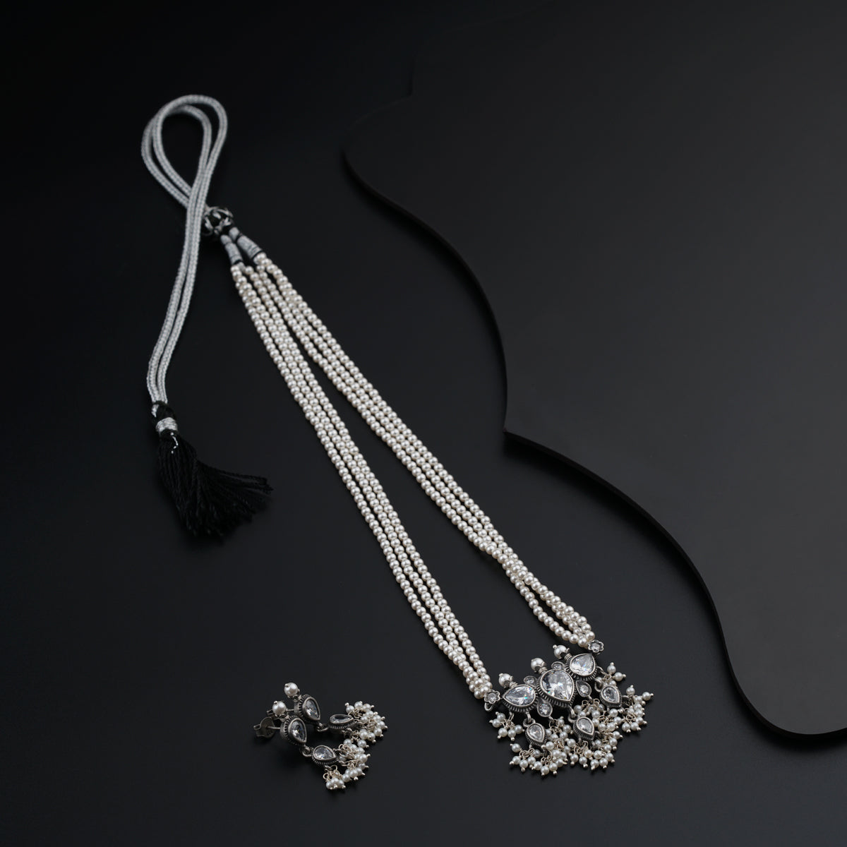 a pair of pearls and tassels on a black surface