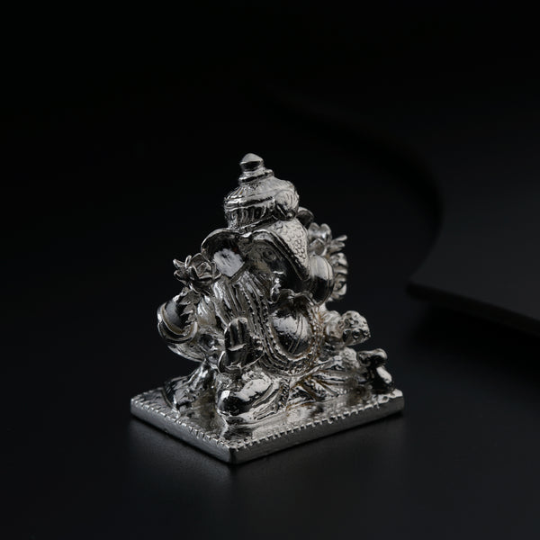 a silver statue sitting on top of a black table