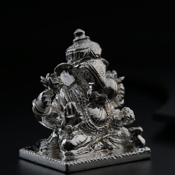 a silver statue of an elephant on a black background