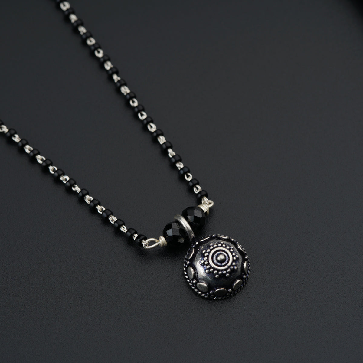 a black and silver necklace with a pendant on it