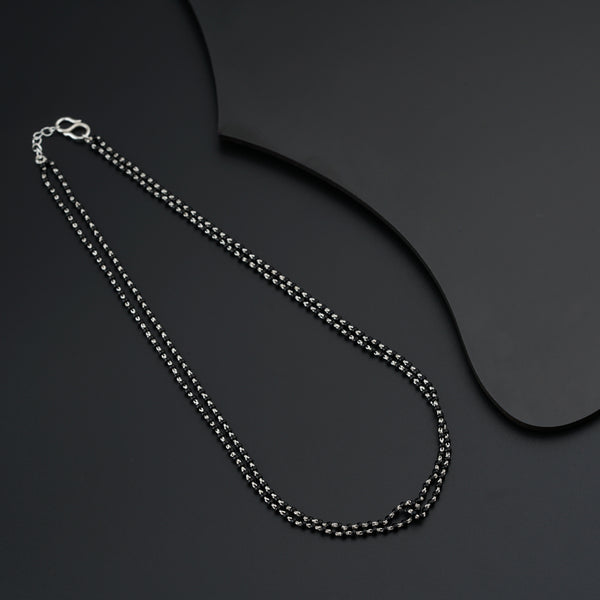 a black and silver necklace on a black surface