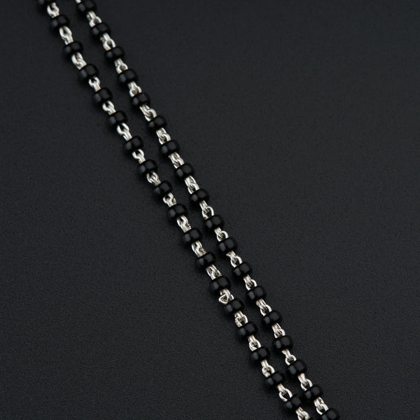 a close up of a black and silver necklace