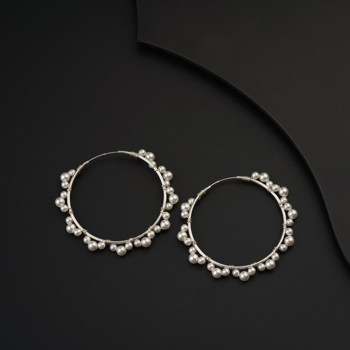 a pair of silver hoop earrings with pearls