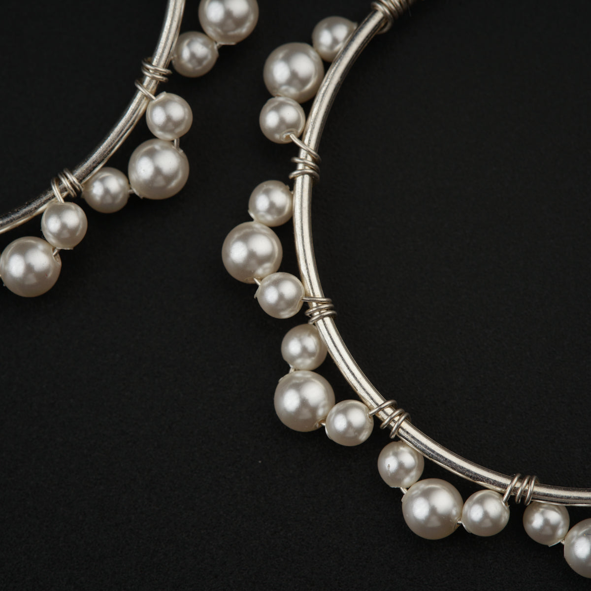 a close up of a pair of earrings with pearls