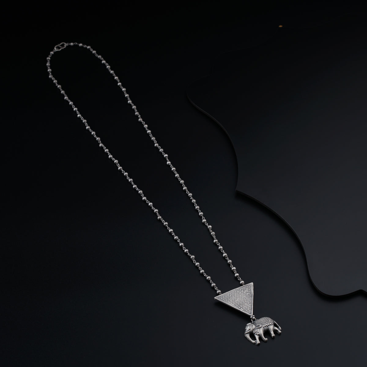 a silver necklace with an elephant on it