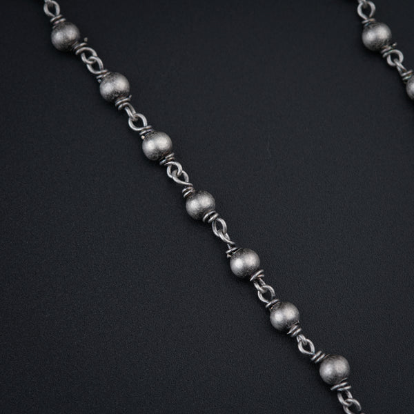 a chain of silver beads on a black background