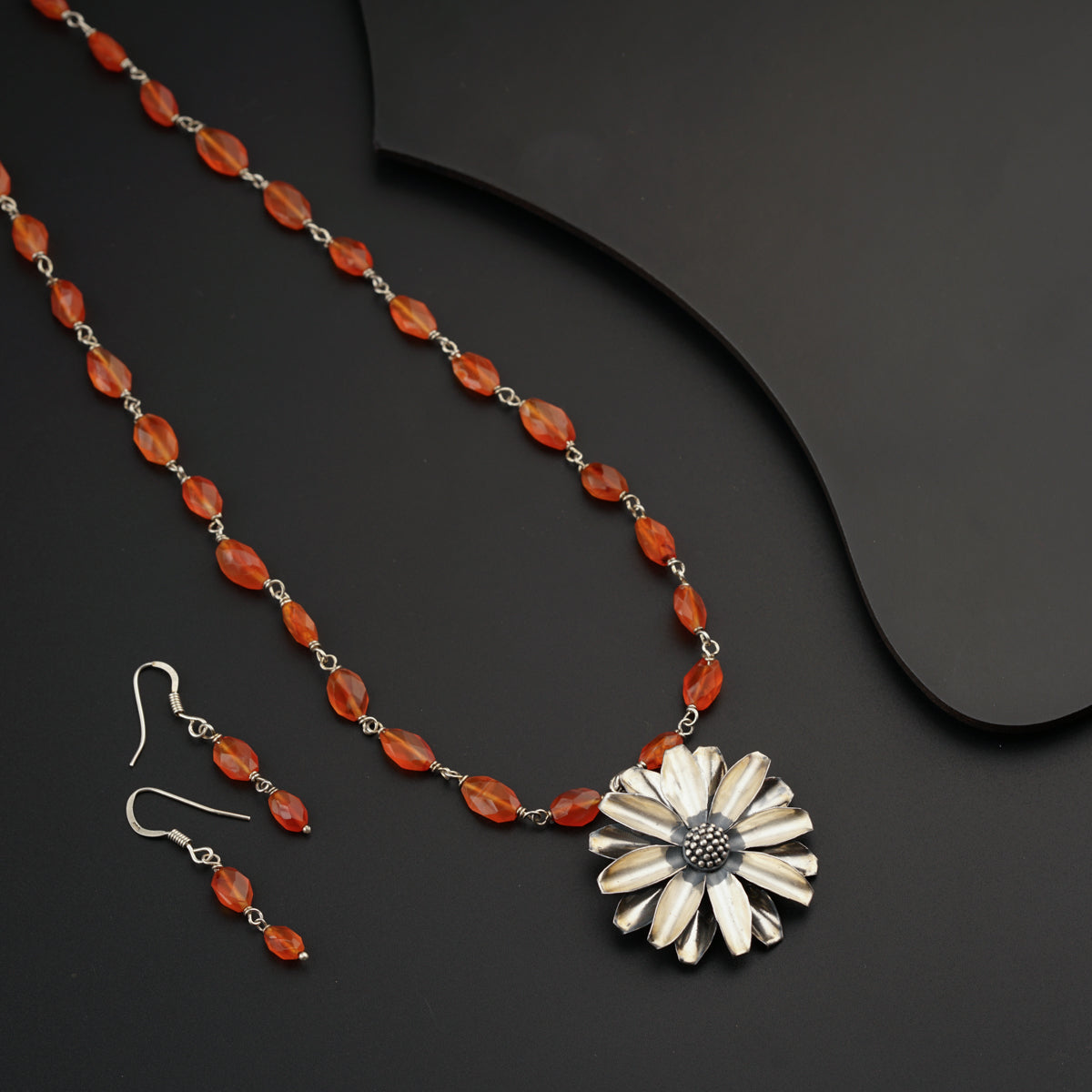 a necklace and earring set with a flower