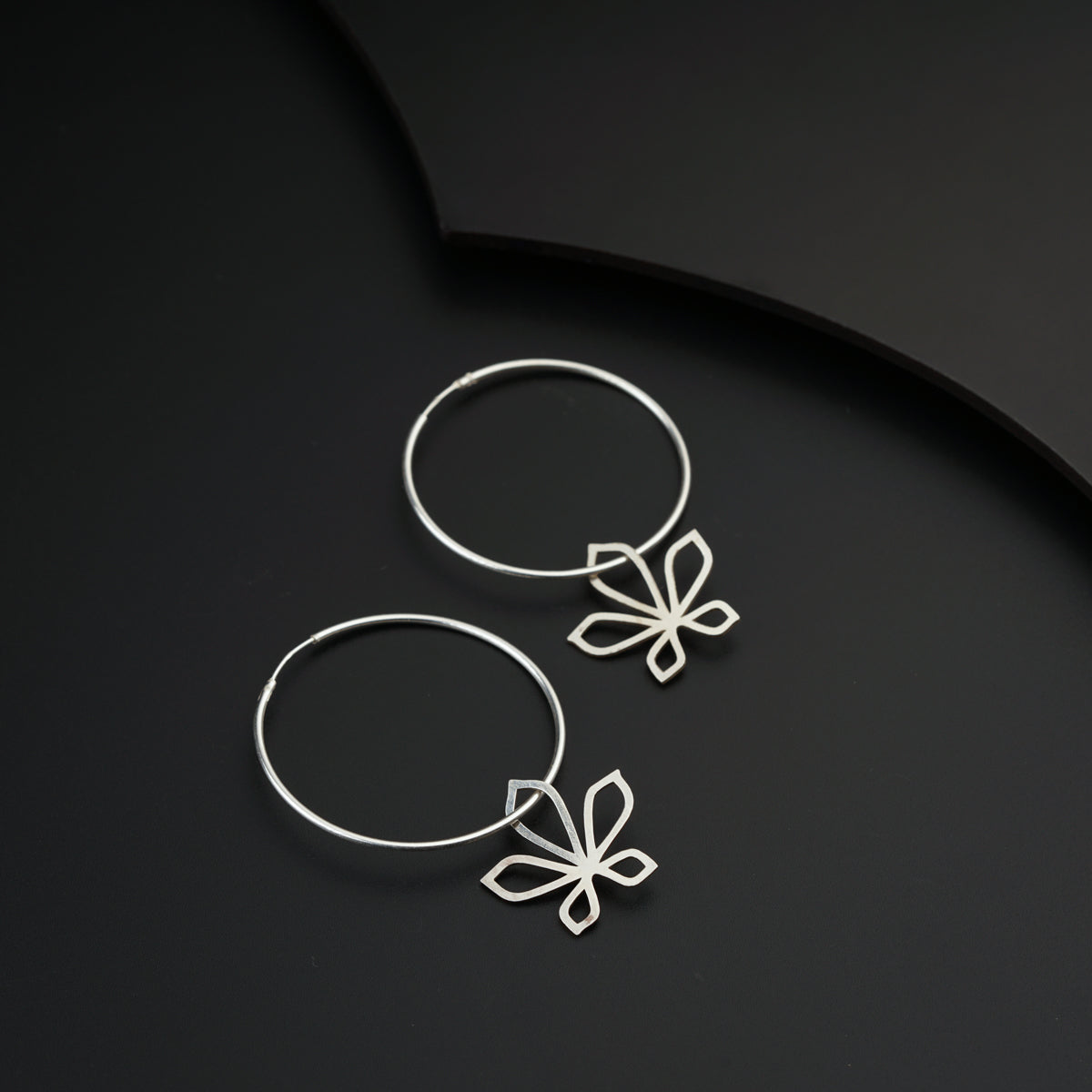 a pair of silver hoop earrings with a bow