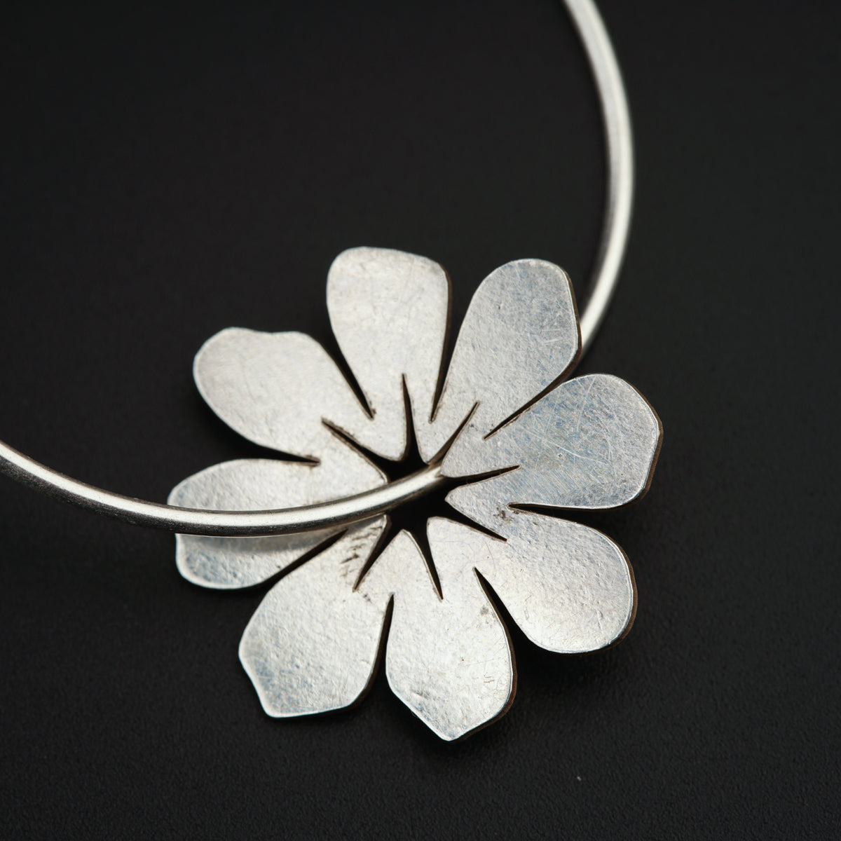 a close up of a flower on a necklace