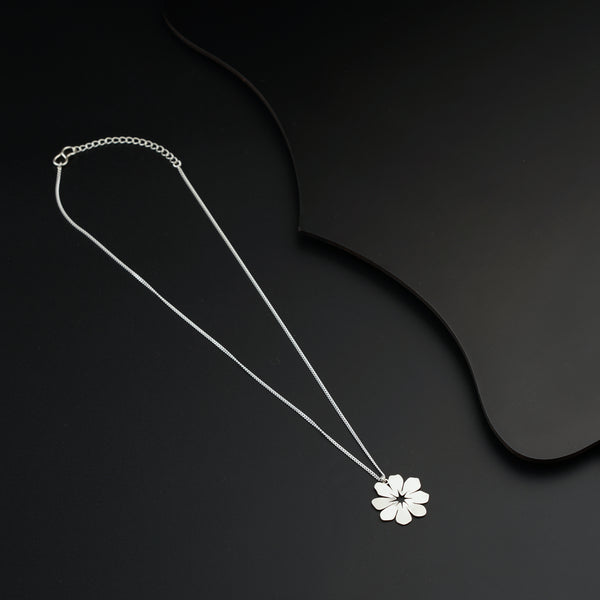 a necklace with a flower on a black background