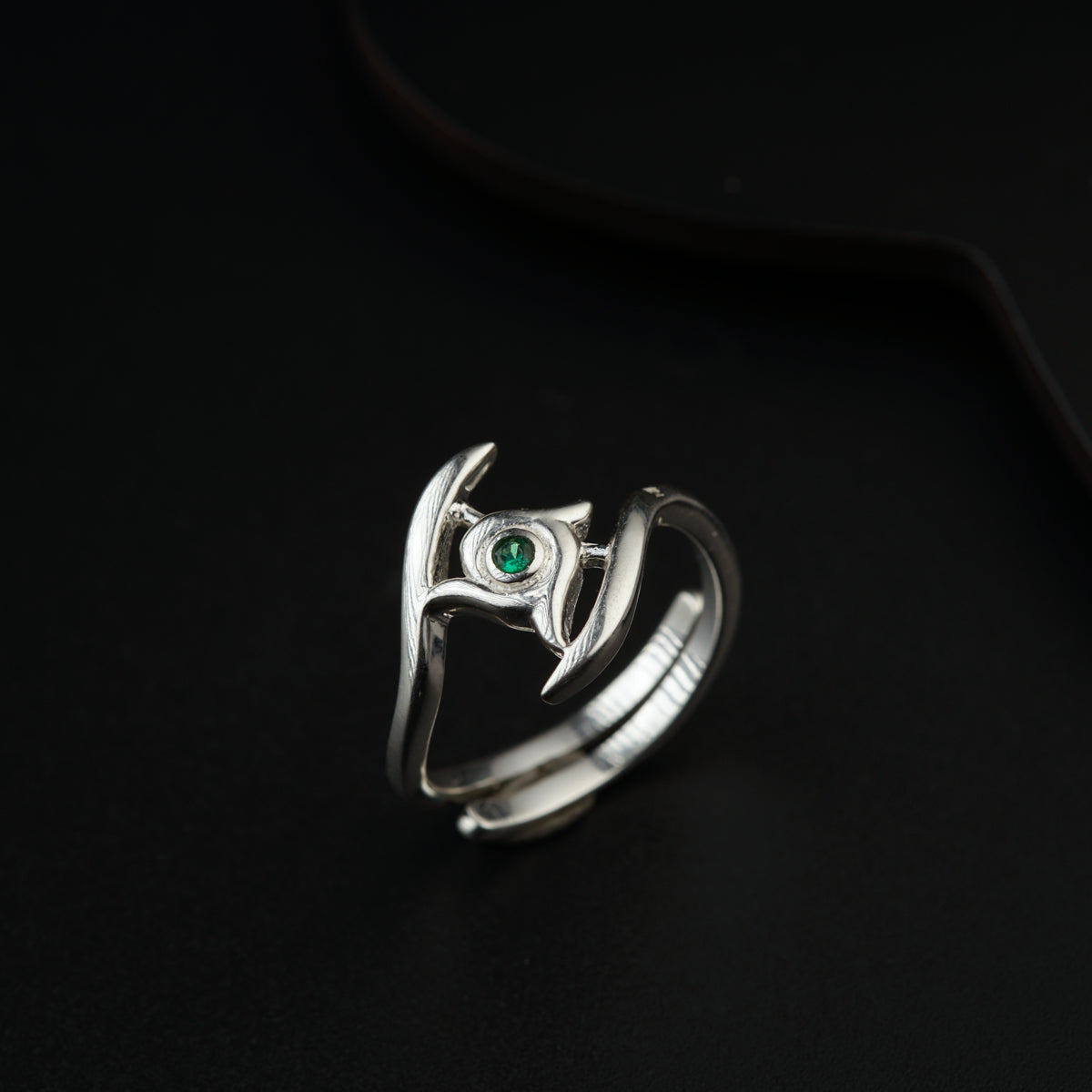 a silver ring with a green stone in the middle
