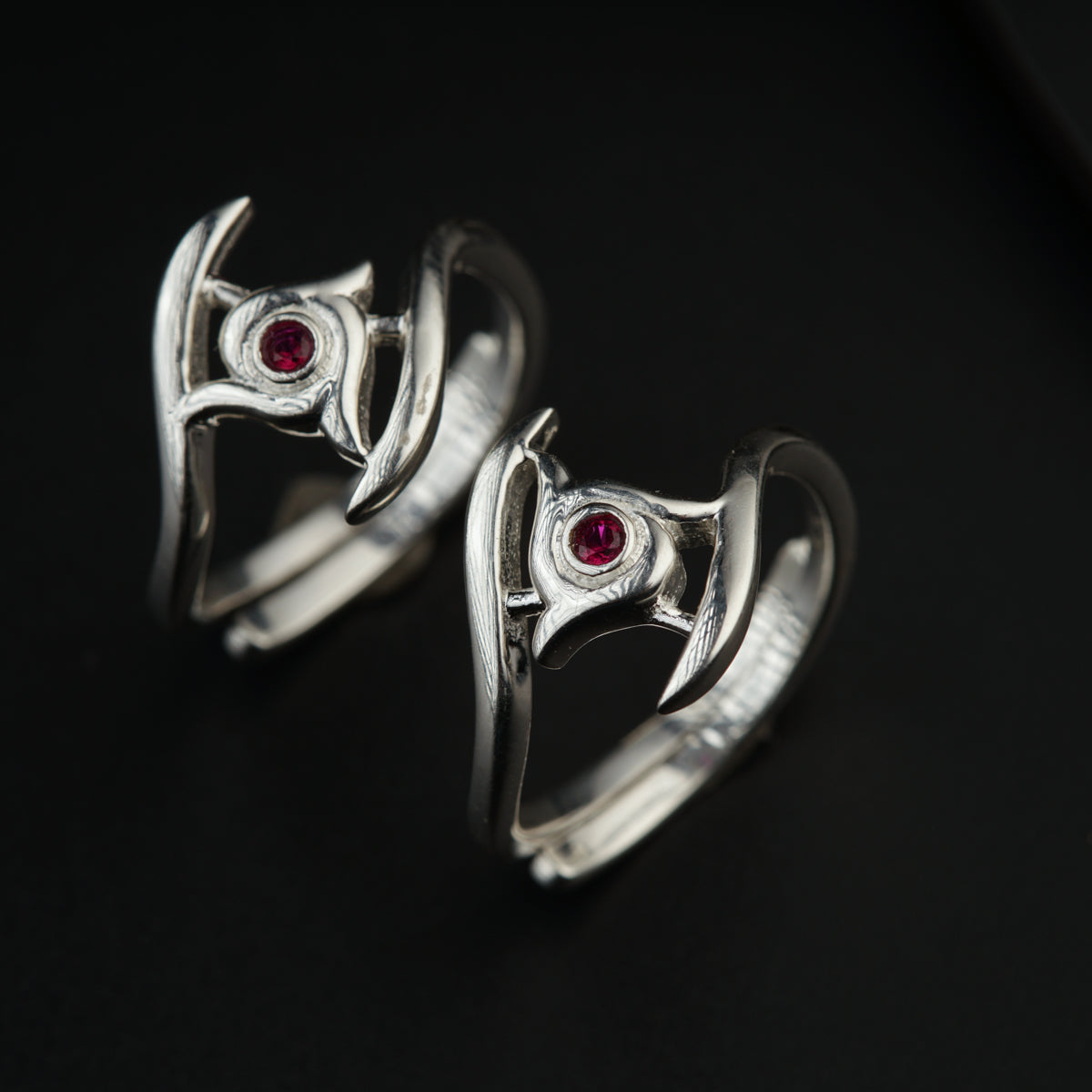 a pair of silver rings with red stones