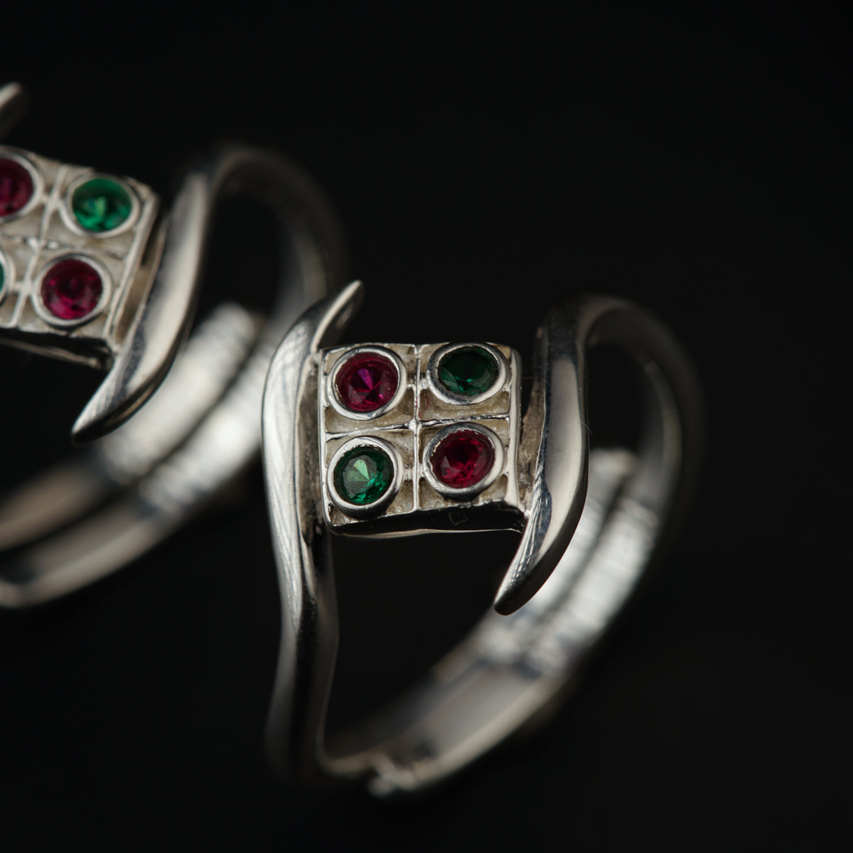 two silver rings with different colored stones on them