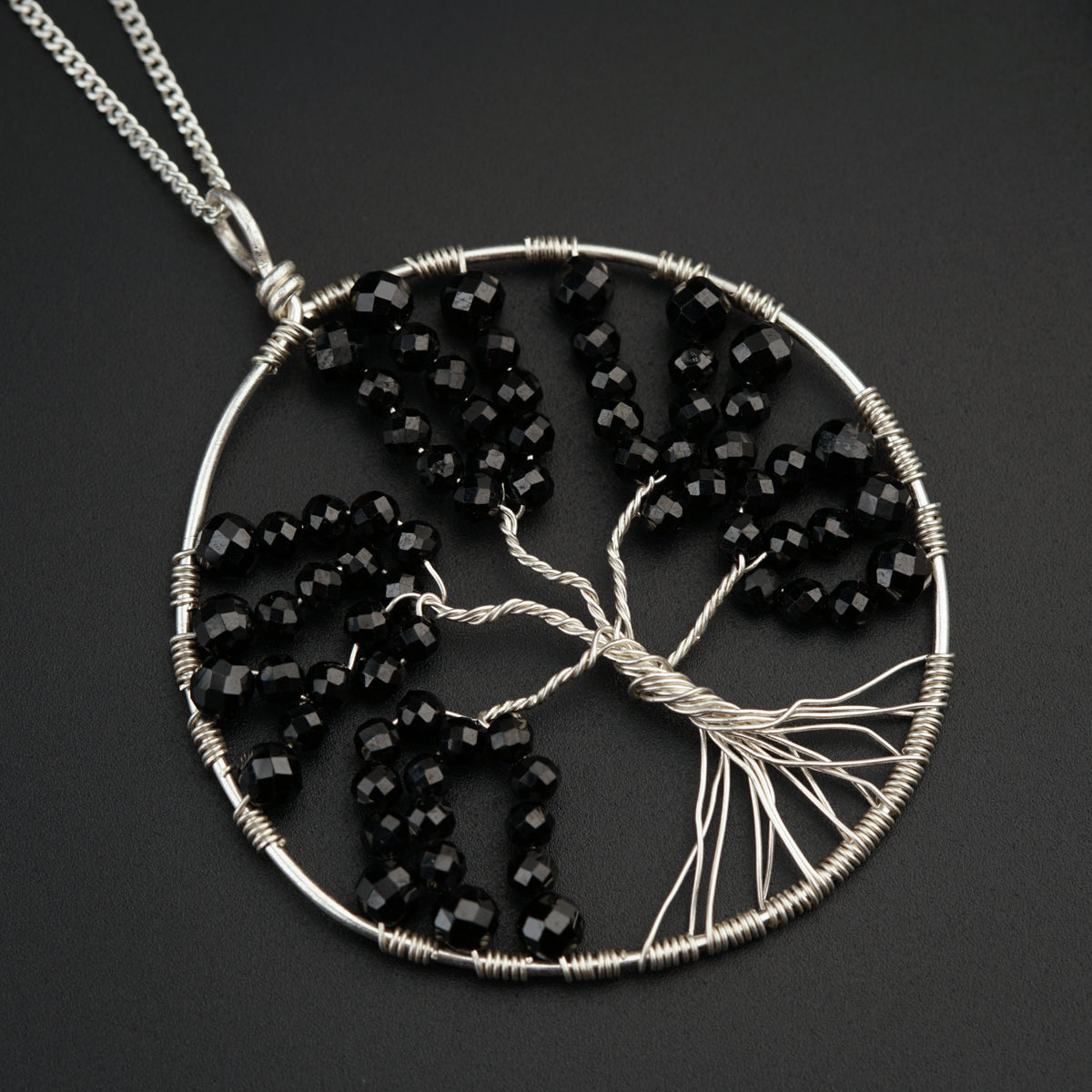 a tree of life pendant with black beads