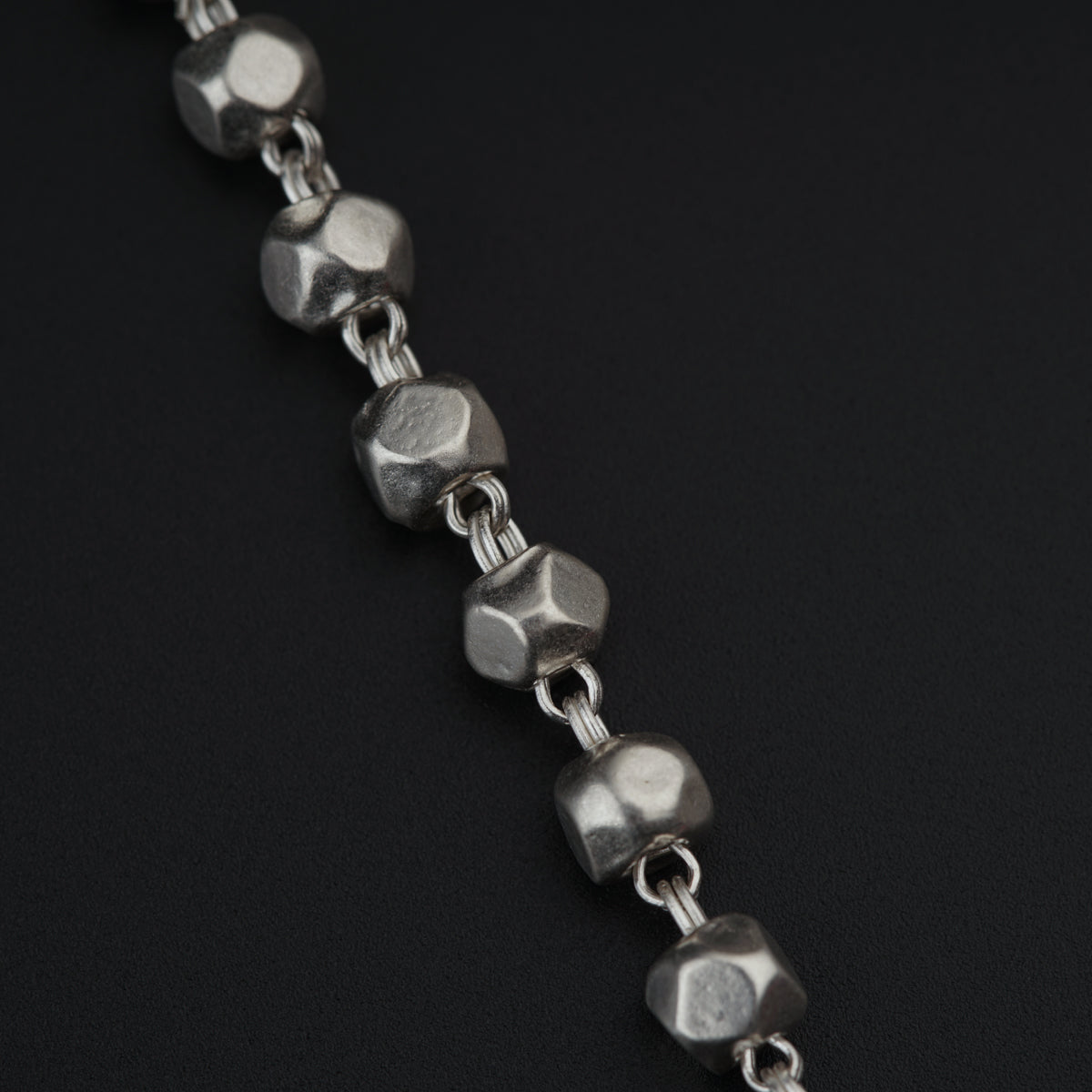 a close up of a metal bracelet on a black surface