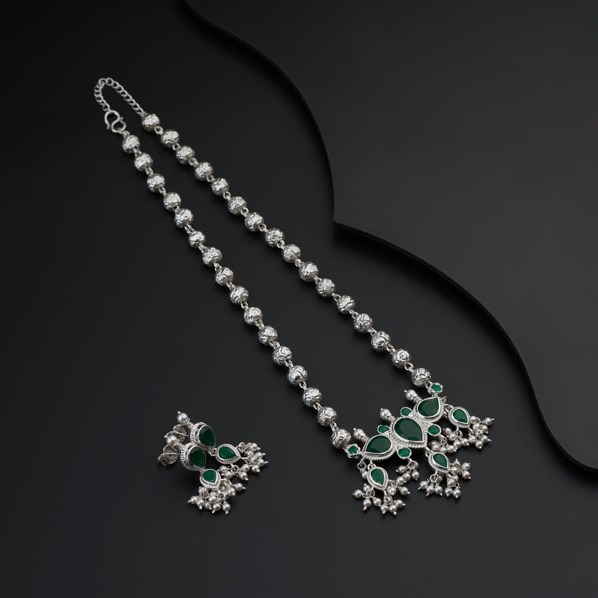 a necklace and earring set with green stones
