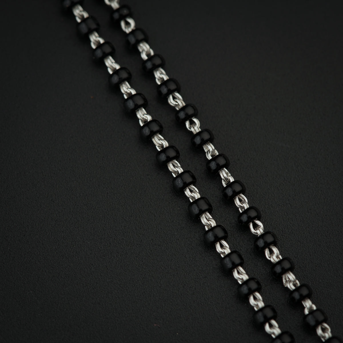 a close up of a black and silver beaded necklace